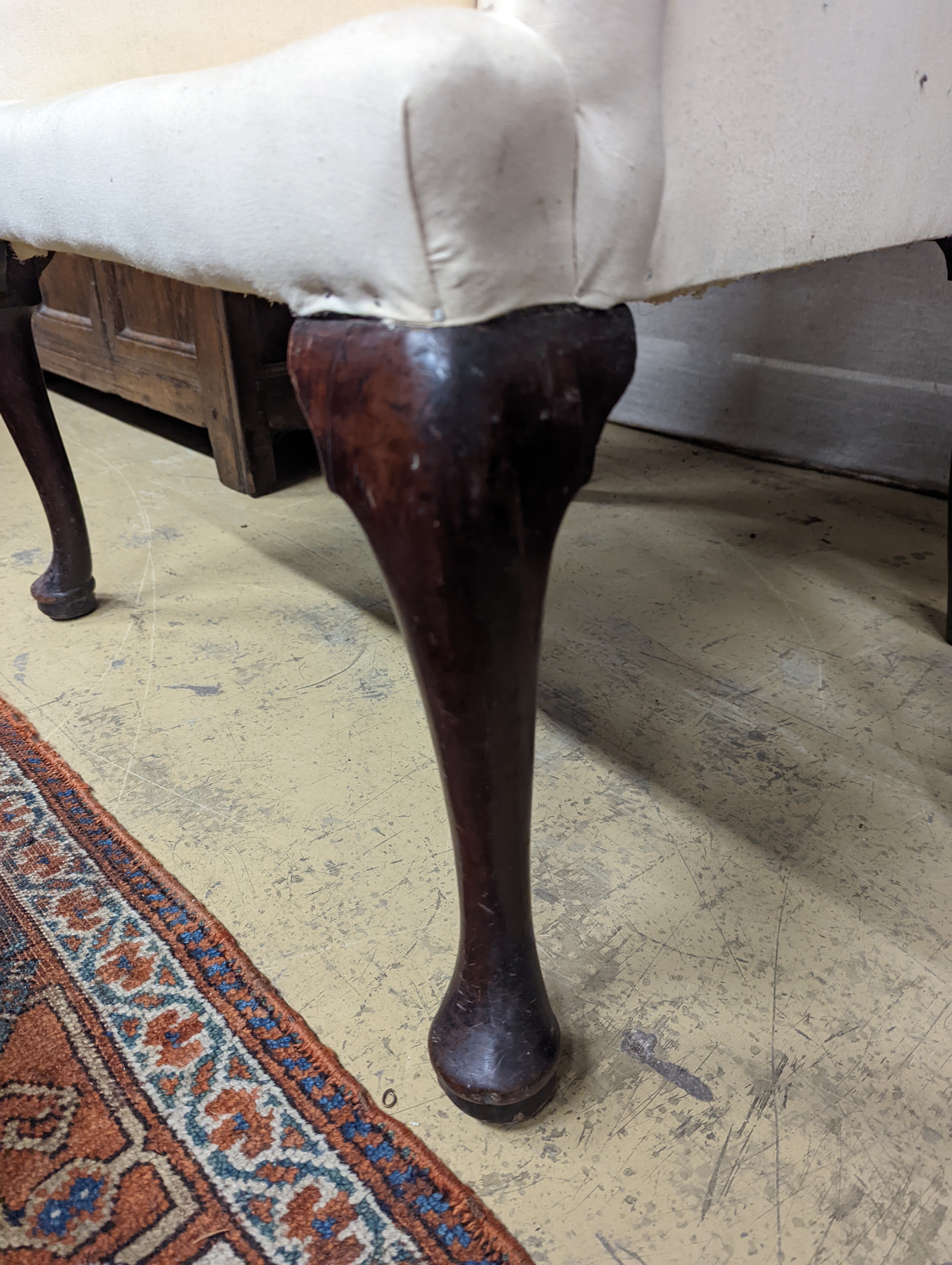 A George II mahogany wingback armchair, with slender cabriole legs and pad feet, width 80cm, depth 66cm, height 126cm